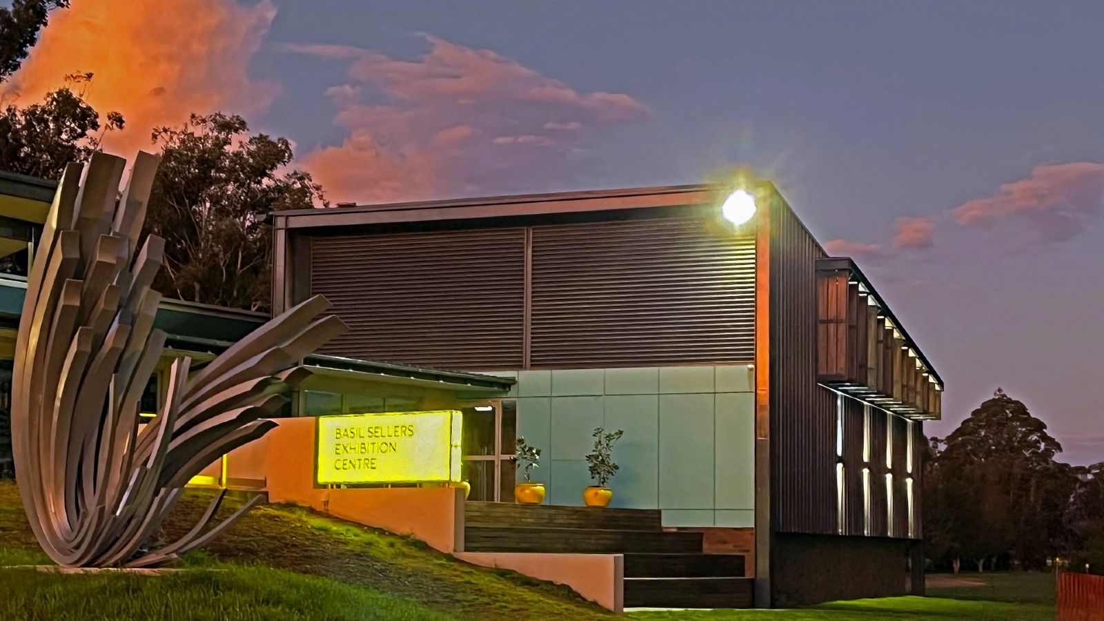A night shot of a building showing signage and lighting and sunset. banner image