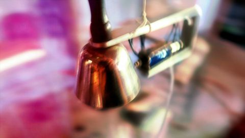Image of a small bell and knocker with a blurred background.
