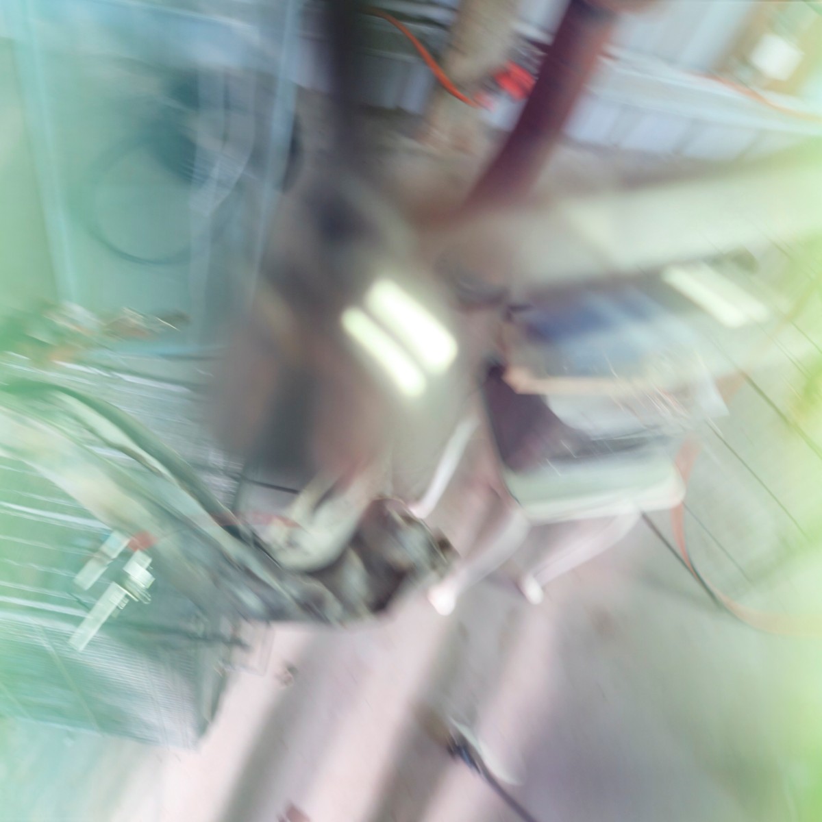 Image Blurred view of a makeshift installation with wires, a small device and found materials.